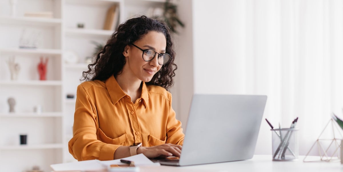 professional woman working at desk with laptop